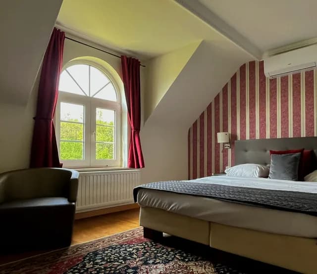 Hotelkamer met rode gordijnen en gestreept behang