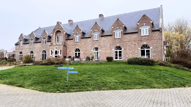 The front of the building with signs to reception and parking